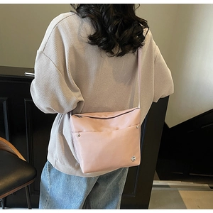 Vue arrière d'un mannequin portant le sac seau en oxford rose avec détails de rivets