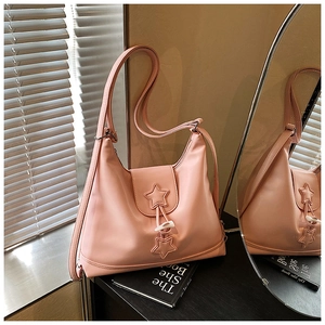 Detail of pink PU leather hobo bag with star patch and white toggle closure