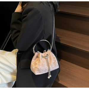 Detailed close-up of pink jacquard bucket bag with butterfly pattern and pearl chain tassel