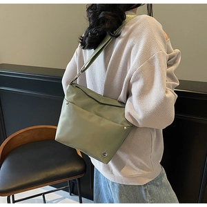 Détail du tissu oxford vert clair et du logo métallique sur le sac seau tendance