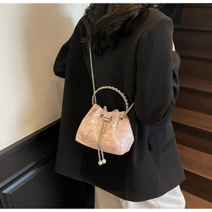 Detail showing pink floral jacquard fabric with metallic ring handle and pearl chain