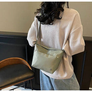 Détail du sac bandoulière Oxford vert sauge avec sangle réglable et logo métal
