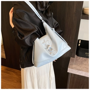 Detailed side view of light blue leather tote bag with star stitching and horn buckle