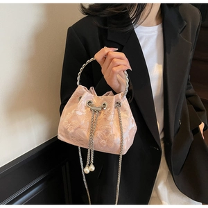 Detail of pink jacquard bucket bag with floral butterfly embroidery and pearl accents