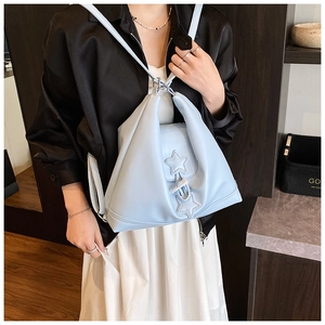 Close-up of light blue synthetic leather bag featuring star accents and geometric folds