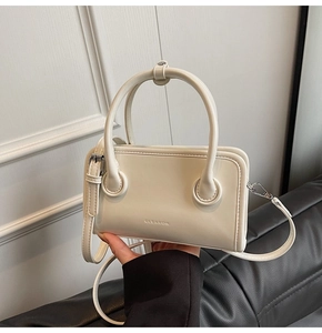 Detail of white leather handbag showing clearok logo and silver hardware buckle