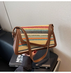 Detail of colorful rainbow straw woven bag with brown leather trim and metal buckle
