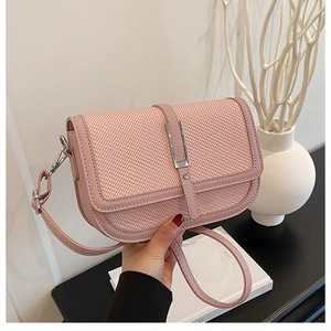 Close-up of pink woven texture crossbody bag with silver hardware and adjustable strap