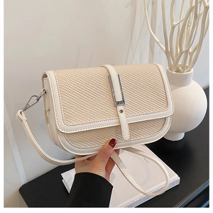 Detail of cream woven texture and smooth leather trim on a vintage crossbody bag