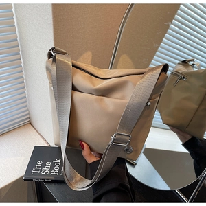 Détail du sac seau en oxford kaki avec large bandoulière en nylon gris argenté et poche