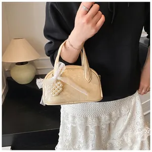 Sac à main crème demi-lune avec nœud en dentelle et détail de breloque cœur en perles