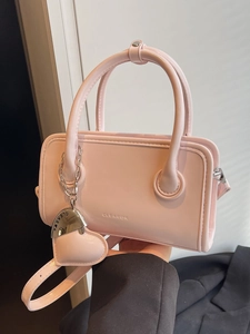 Pink faux leather fashion handbag with CLEAROK embossing and a heart chain charm accessory