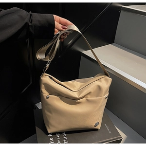 Détail du sac seau en nylon kaki avec clous métalliques et fermeture éclair