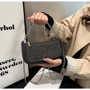 Close-up of elegant black rhinestone baguette bag with fine silver metal chain strap