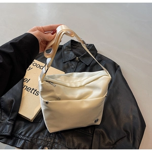 Détail du sac seau bandoulière blanc crème avec large sangle et poches zippées