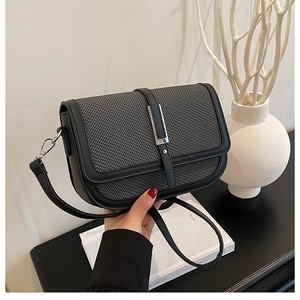 Detail of saddle bag showing woven grey texture and polished black leather contrast