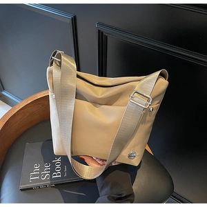 Détail du sac seau en nylon kaki avec zip argenté et bandoulière tissée large