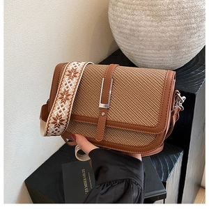 Detailed macro view of vintage brown woven crossbody bag with geometric jacquard strap