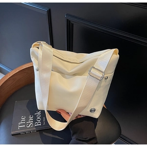 Détail du sac seau blanc crème en tissu oxford avec boucle en métal et badge