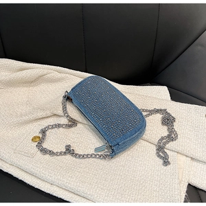 Detailed macro of blue denim bag with sparkling silver rhinestones and chain strap