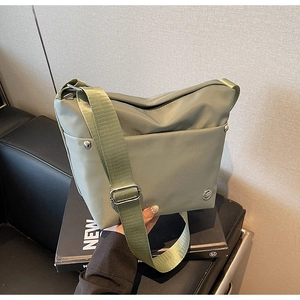 Gros plan détaillé du sac seau en nylon vert sauge avec rivets argentés de qualité