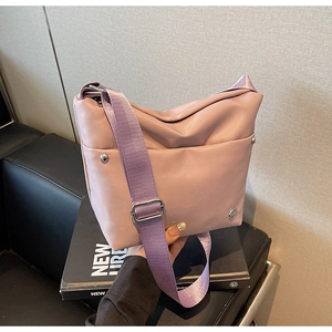 Détail du sac seau en nylon rose avec rivets argentés et bandoulière en tissu violet