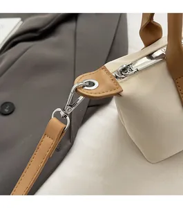 Detailed close-up of high-quality silver metal hardware and brown leather handle on a bag