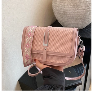 Detail of pink woven texture crossbody bag with stylish embroidered wide strap
