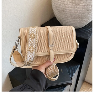 Close-up of beige woven crossbody bag featuring vintage style and ethnic embroidery strap