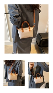 Detailed shot of beige canvas and brown leather bucket bag with metallic logo