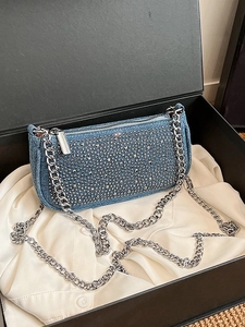 Blue denim saddle bag with silver rhinestones and chain strap in a gift box