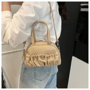 Détail du sac bowling beige à plis avec bandoulière réglable porté par un mannequin