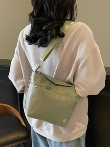 Sac seau en tissu Oxford vert avec bandoulière réglable porté par un mannequin