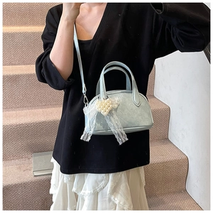 Sac bandoulière bleu brillant avec pendentif cœur en perles et nœud dentelle sur modèle