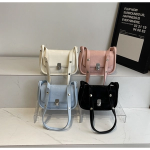 Detail view of four textured crossbody bags in beige, pink, blue, and black with metal locks