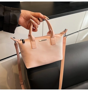 Detail of light pink nylon bucket bag with silver metal hardware and detachable strap