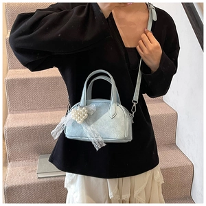 Détail du sac oreiller bleu clair avec cœur en perles et décoration en dentelle