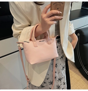 Detail of pink PU leather bucket bag with metal plate and adjustable shoulder strap