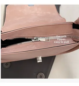 Detail of pink crossbody bag showing smooth silver zipper and metal turn-lock closure