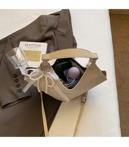 Spacious interior of a cream lychee pattern handbag with pearl bow and daily essentials