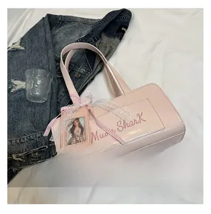 Borsa a mano rettangolare in ecopelle rosa con logo ricamato e ciondolo in pizzo