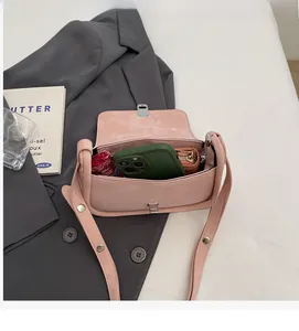 Interior storage view of a matte pink flap crossbody bag holding a phone and wallet
