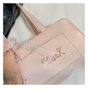 Dettaglio borsa in pelle rosa con ricamo Miss Shark e porta carte in pizzo
