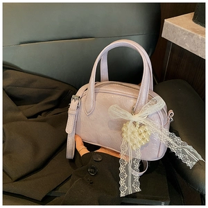 Détail du cuir plissé lavande avec nœud en dentelle et pendentif cœur en perle