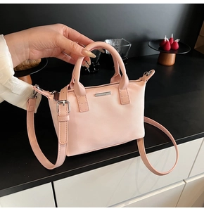 Pink nylon bucket bag detail with silver plaque, dual handles and adjustable strap