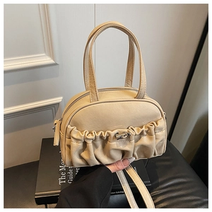 Vue détaillée du sac bowling plissé beige avec fermoir argenté et bandoulière réglable