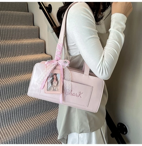 Dettaglio borsa a spalla in ecopelle rosa con fiocco in pizzo e scomparto per carta