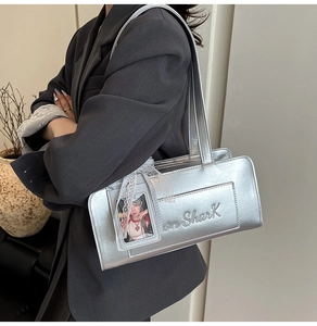 Dettaglio borsa a spalla rettangolare argento con goffratura Shark e ciondolo in pizzo