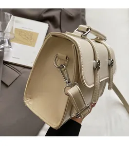 Détail du sac à main crème en similicuir plissé avec des ferrures argentées brillantes