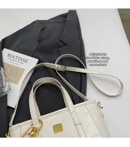 Detail of white embossed crossbody bucket bag with cartoon patterns and scarf decor